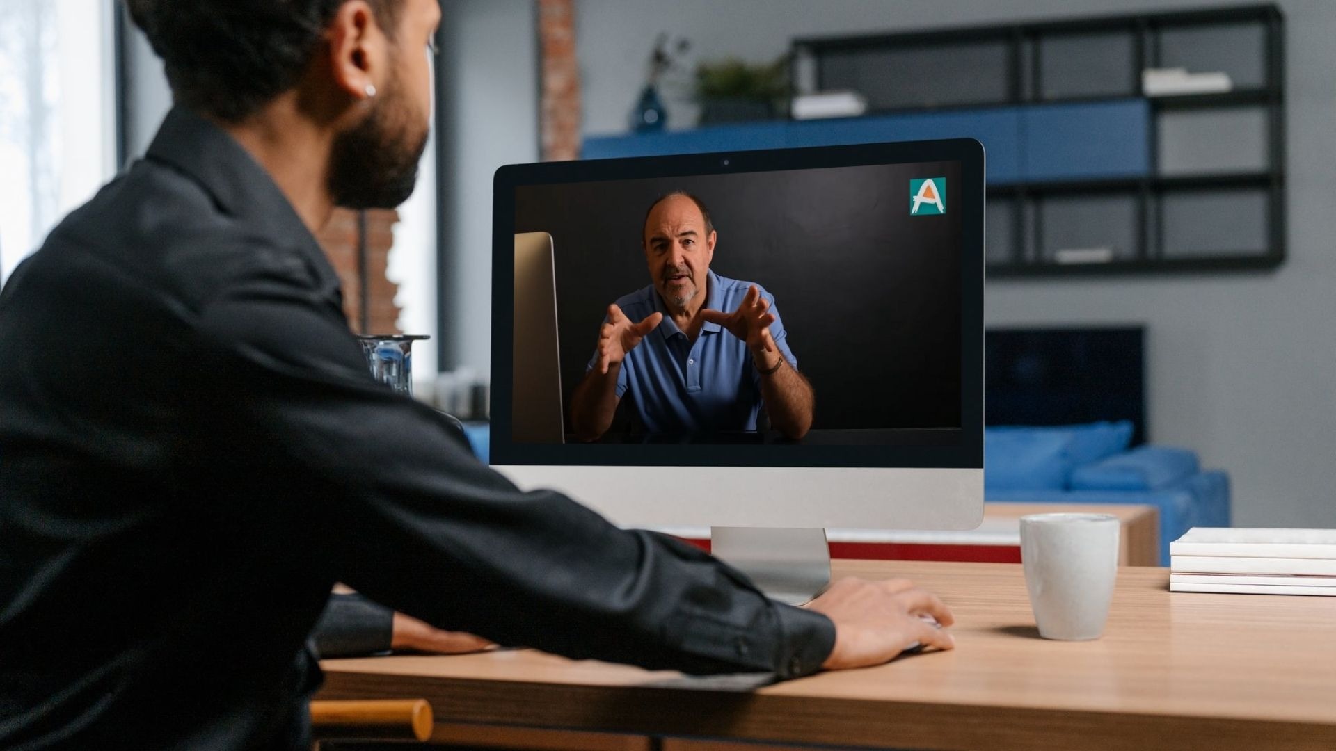 Student at a desk watching Martin Osner teach a live class on screen